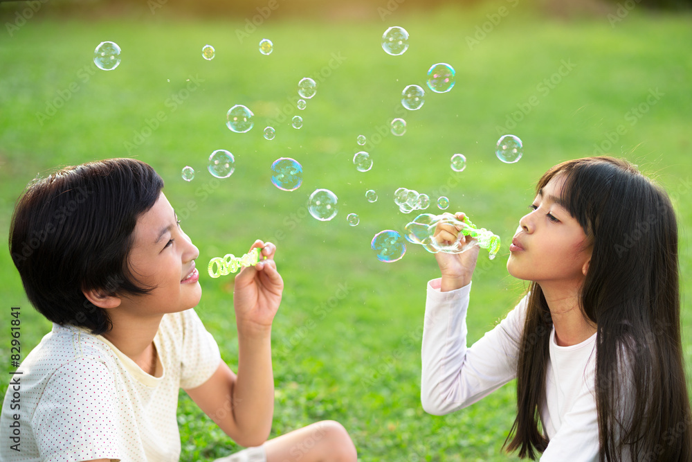 Children in the park blowing soap bubbles Children in the park blowing soap bubbles