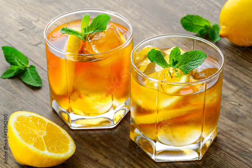lemon ice tea on brown wooden table with lemons around