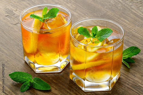 lemon ice tea on brown wooden table with lemons around