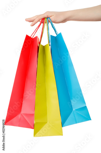 Female hand holding shopping paper bags on white, clipping path