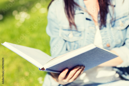 close up of young girl with book in park