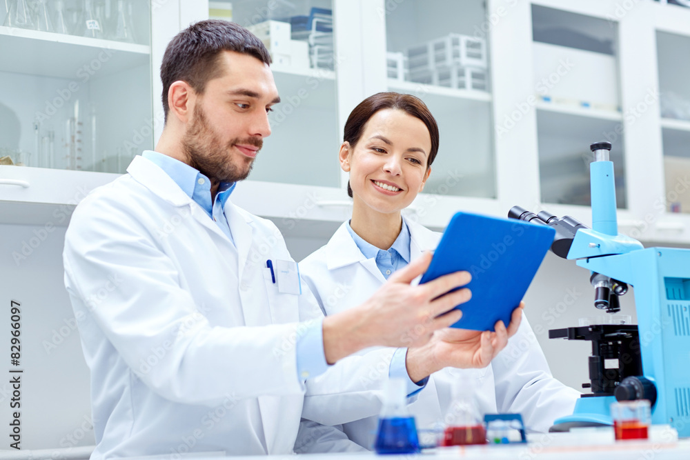 scientists with tablet pc and microscope in lab scientists with tablet pc and microscope in lab