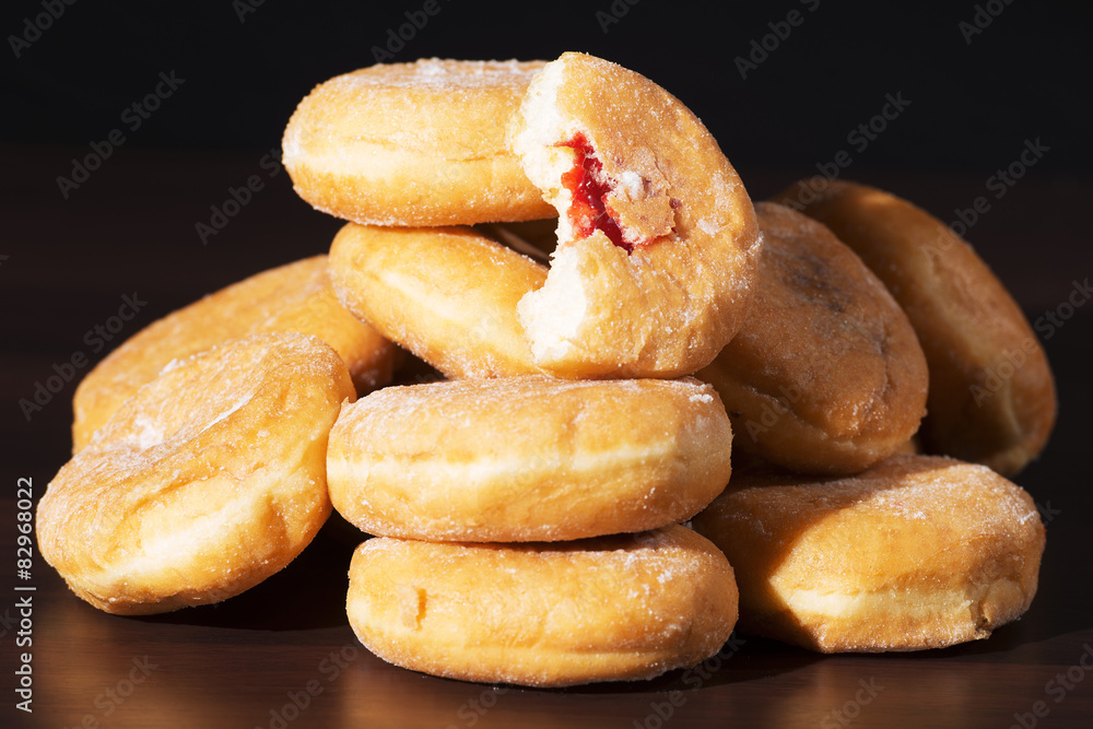 Fototapeta premium Group of fresh baked cinnamon donuts with raspberry jam. 