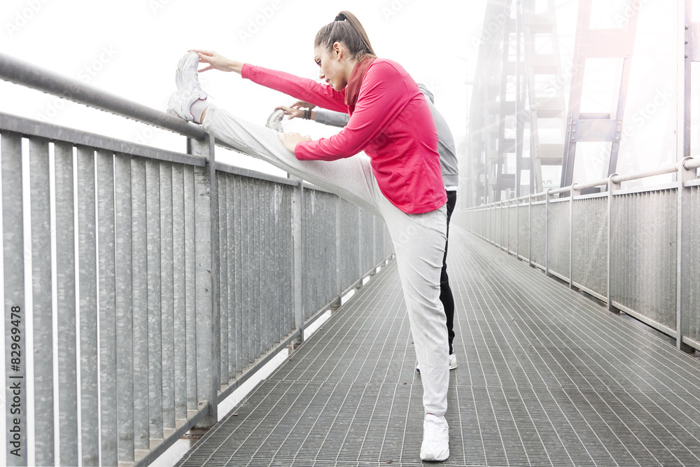 Obraz premium young runner stretch muscles before the race