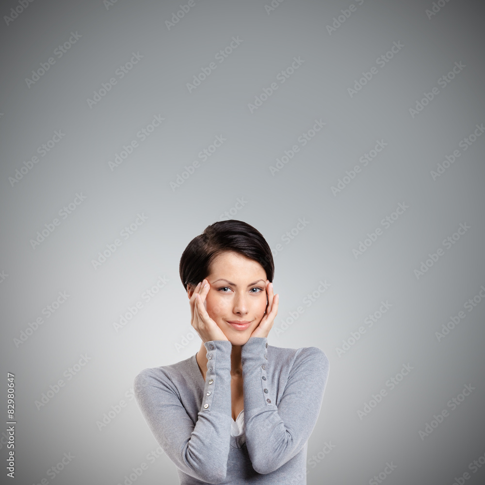 Smart woman admires her own beauty, isolated on grey Smart woman admires her own beauty, isolated on grey
