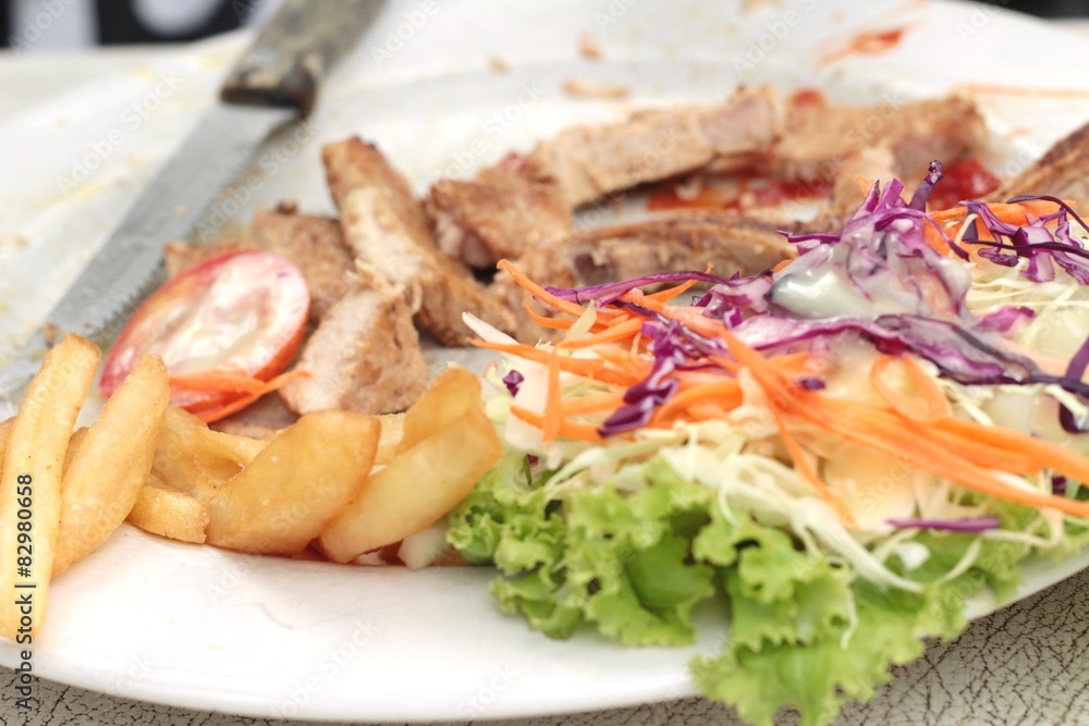 steaks and vegetable salad with french fries. steaks and vegetable salad with french fries.