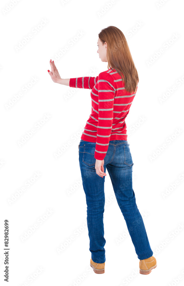 back view of woman. Young woman presses down on something. back view of woman. Young woman presses down on something.