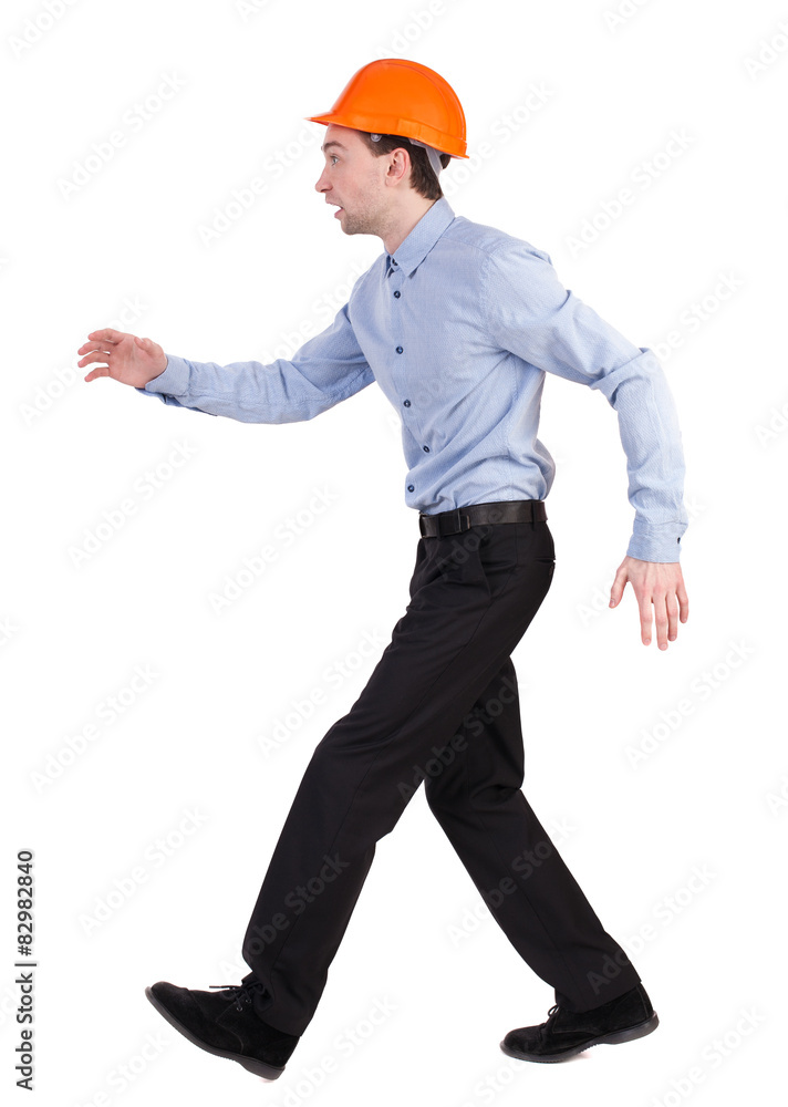 Back view of running engineer in helmet. Walking guy in motion. Back view of running engineer in helmet. Walking guy in motion.