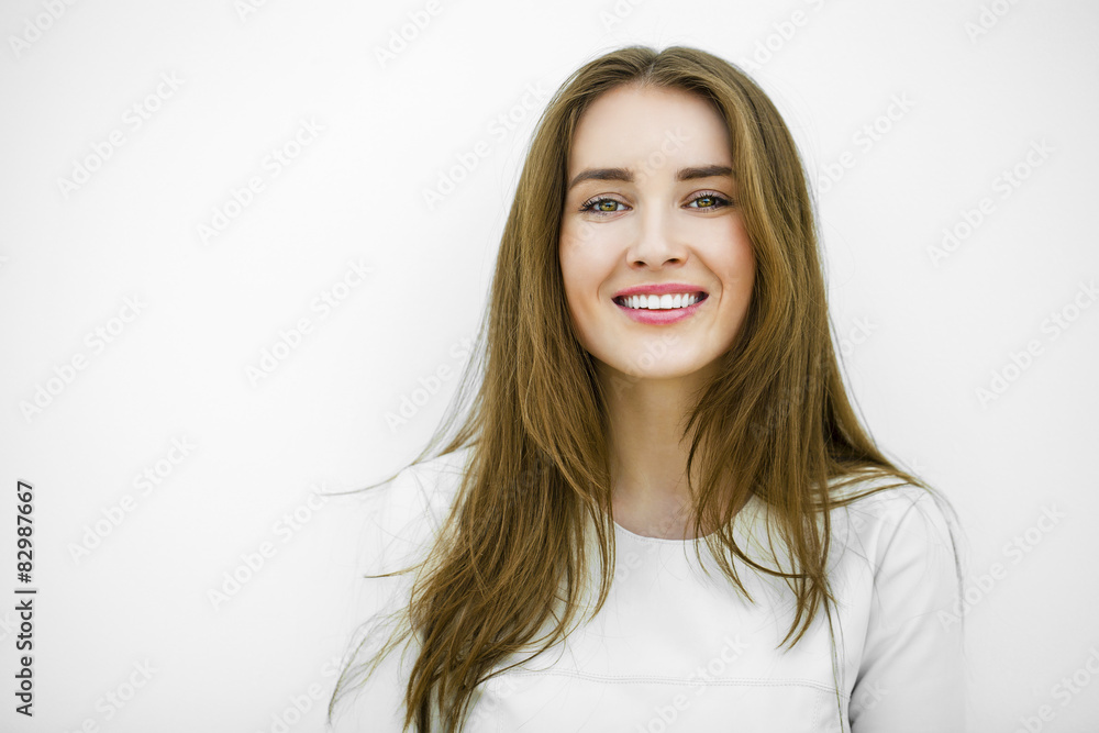 Beautiful young happy woman posing against a white wall Beautiful young happy woman posing against a white wall