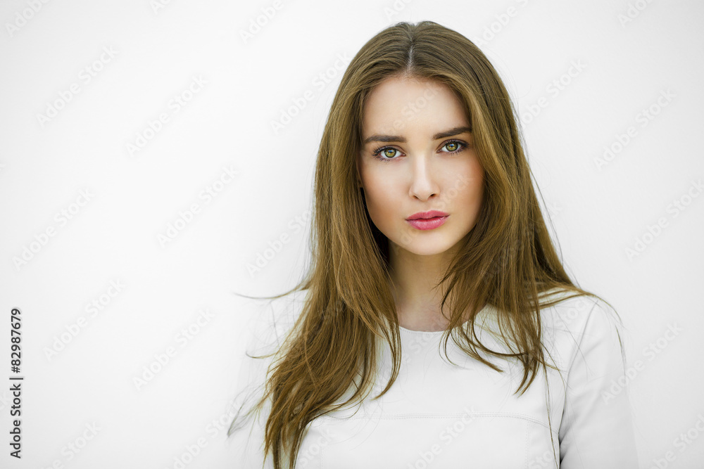 Beautiful young happy woman posing against a white wall Beautiful young happy woman posing against a white wall