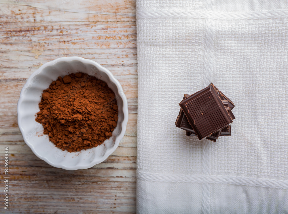 Cube of chocolate and a bowl of cocoa Cube of chocolate and a bowl of cocoa