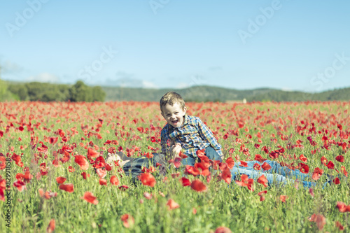 Mother and her little child having fun in a field, flower in for