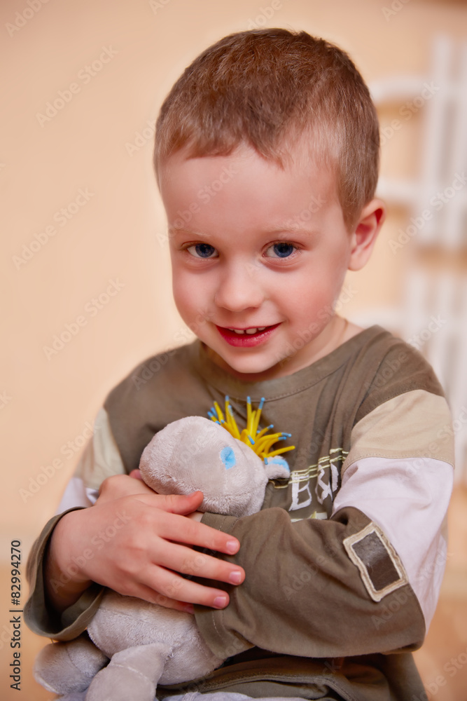Portrait of 3 year-old boy with toy on light background. Portrait of 3 year-old boy with toy on light background.