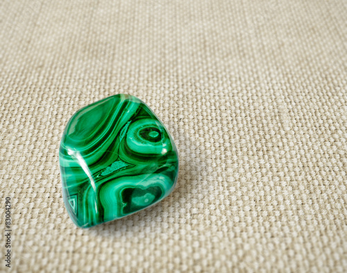Polished malachite stone on canvas background