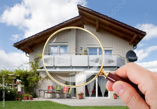Fototapet Hand With Magnifying Glass Over House