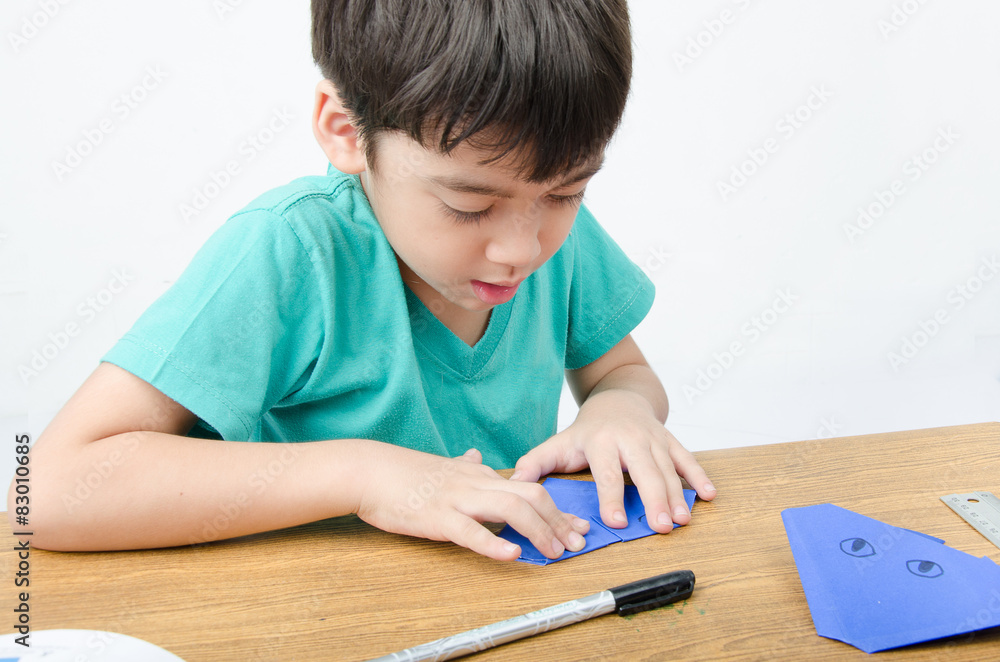 Little boy learning paper art origami Little boy learning paper art origami