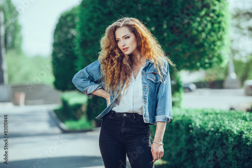 Quadro su tela Beautiful young Caucasian girl with curly hair outdoors