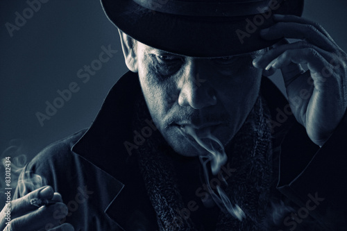 Canvas Print Cold blooded assassin adjusting his hat