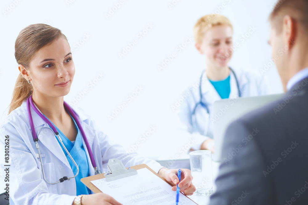 Medical team sitting at the table in modern hospital Medical team sitting at the table in modern hospital