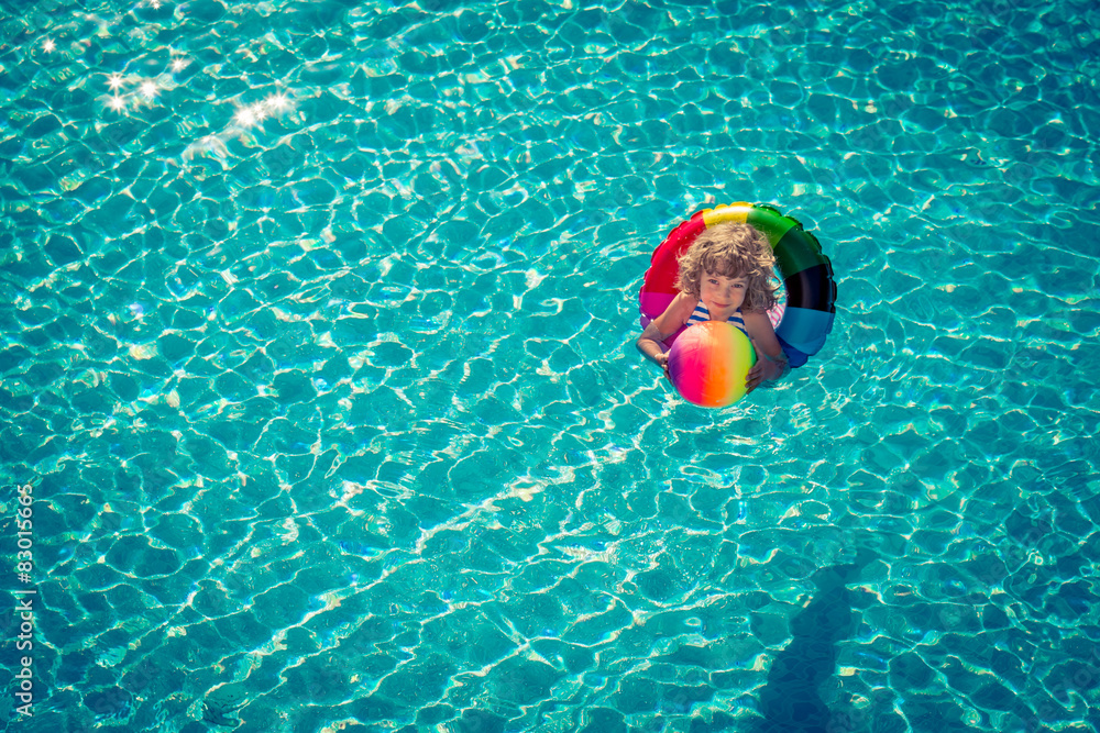 Happy child playing in swimming pool