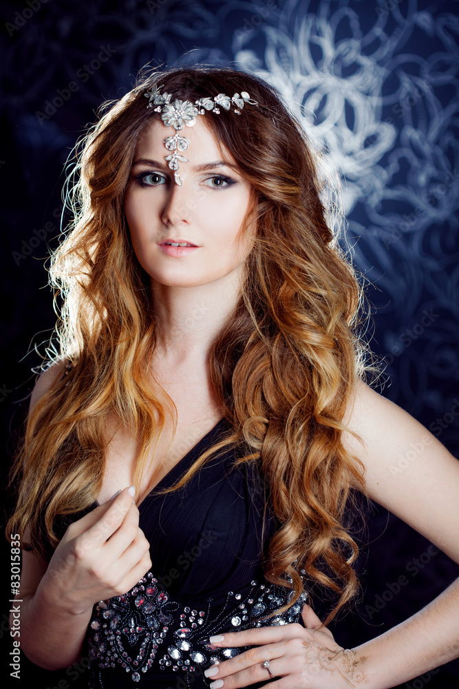 Fototapeta premium beautiful girl with long brown curled hair, decoration on the