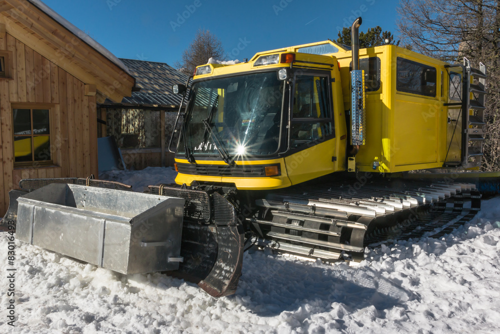 yellow tracked vehicle on snow, grooming machine yellow tracked vehicle on snow, grooming machine