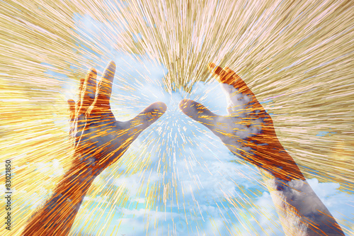 hands raised in prayer against sky. double exposure effect