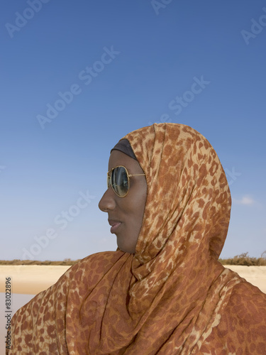 African woman wearing a leopard print headscarf and sunglasses photo