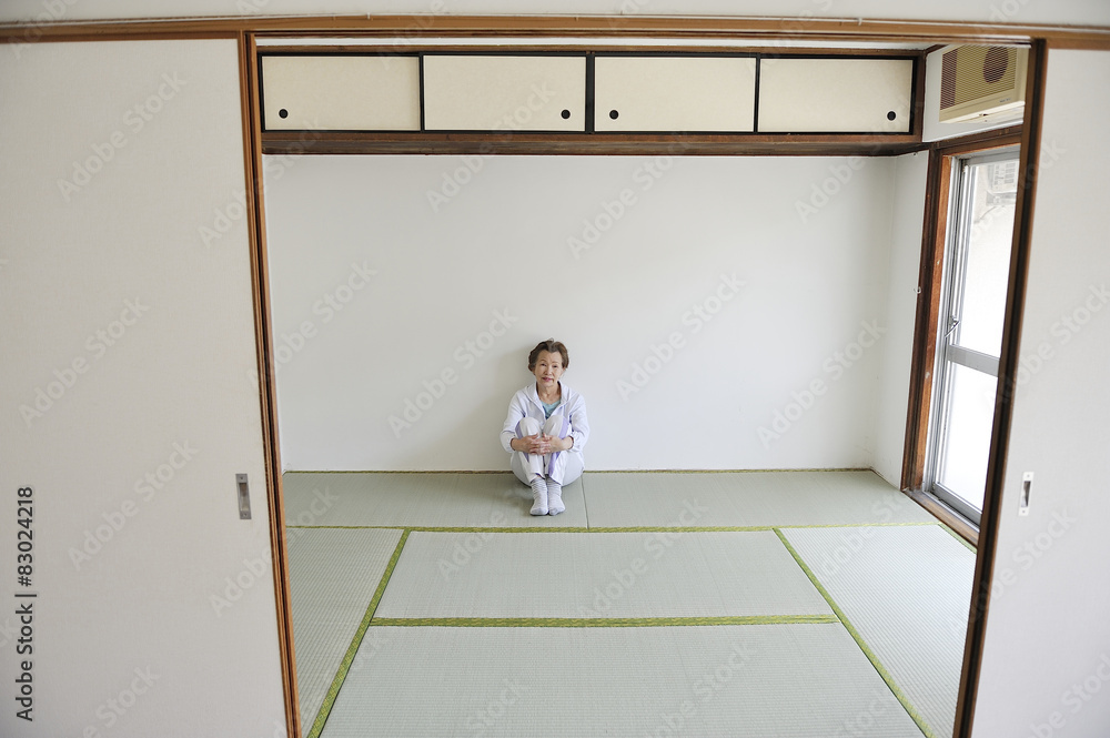 部屋の片隅で寂しく座っているシニアの日本人女性 部屋の片隅で寂しく座っているシニアの日本人女性