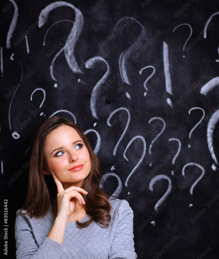 Young girl with question mark on a gray background Young girl with question mark on a gray background