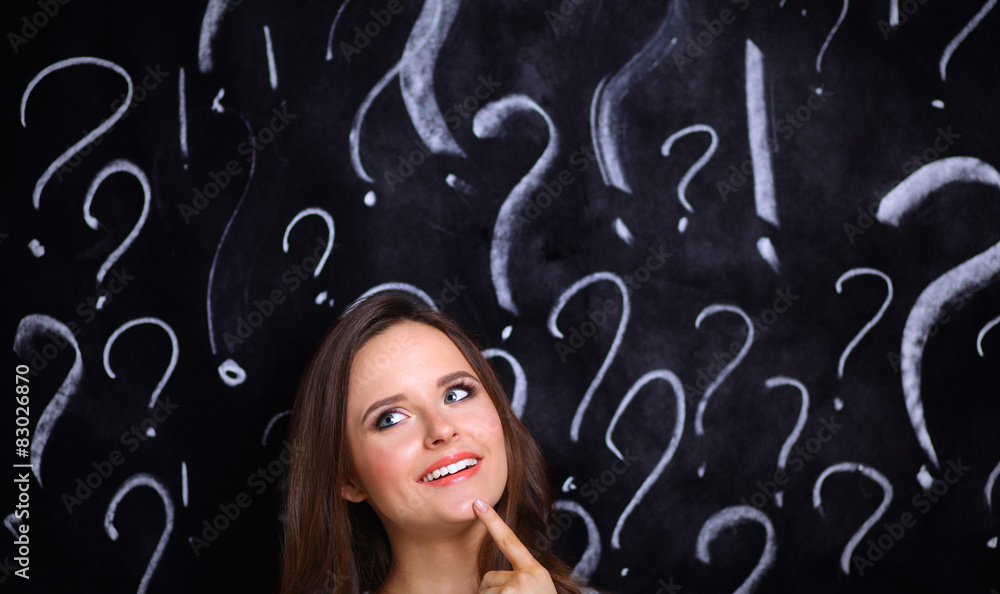 Young girl with question mark on a gray background Young girl with question mark on a gray background