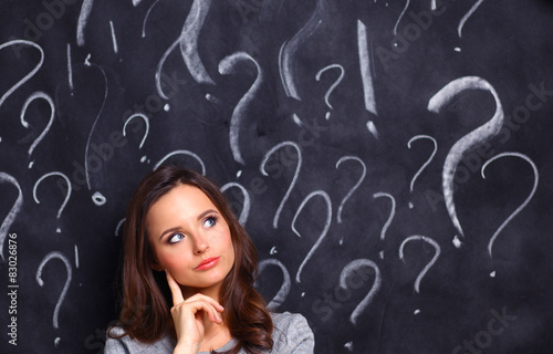 Young girl with question mark on a gray background