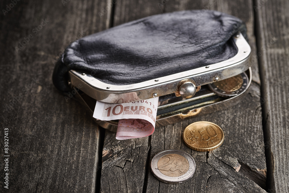 Purse with money on wooden table