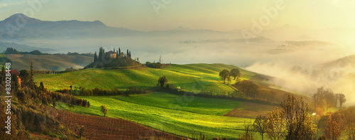 Mist flowing in the green fields of Tuscany in the morning