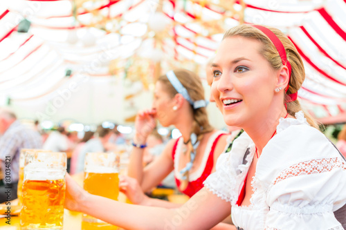 Freundinnen essen kandierte Äpfel beim Oktoberfest