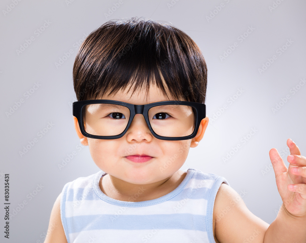 Cute baby boy with black glasses and hand raised up Stock Adobe Stock