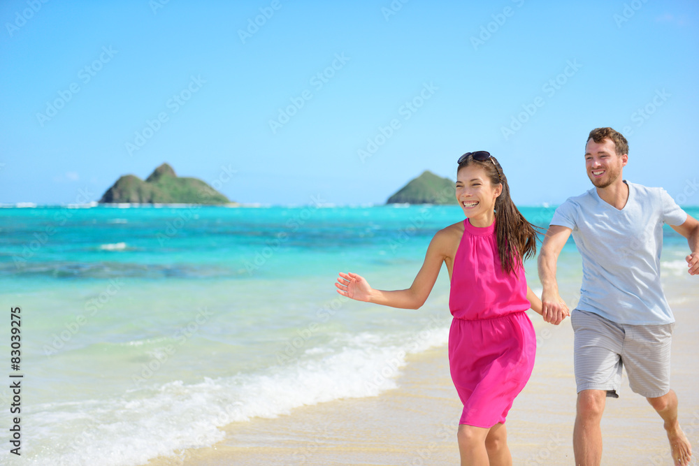 Beach couple happy running having fun on Hawaii Beach couple happy running having fun on Hawaii