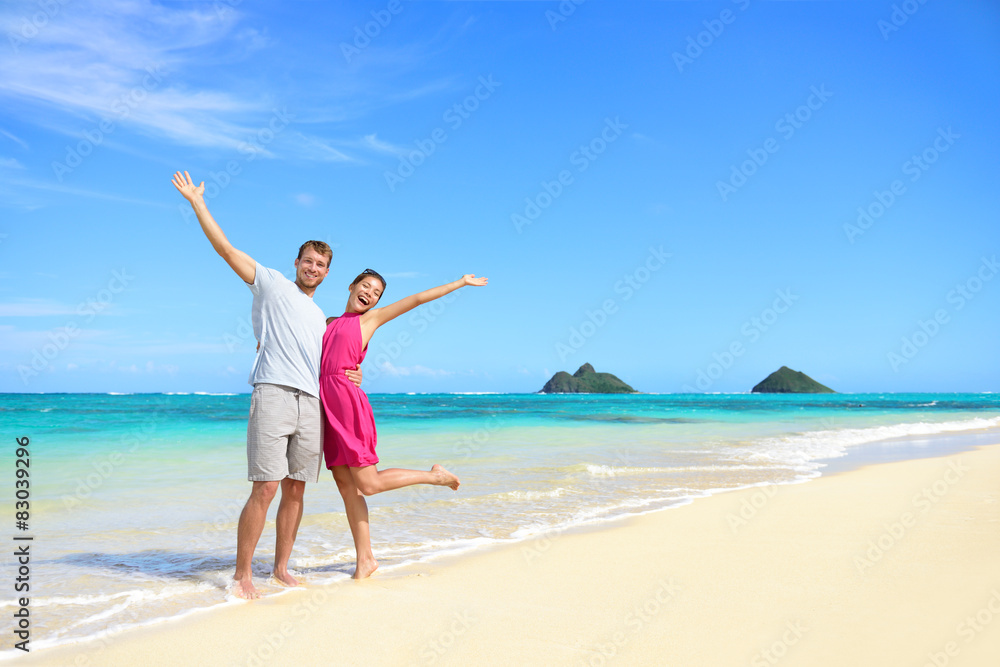 Beach vacation happy carefree couple arms raised Beach vacation happy carefree couple arms raised