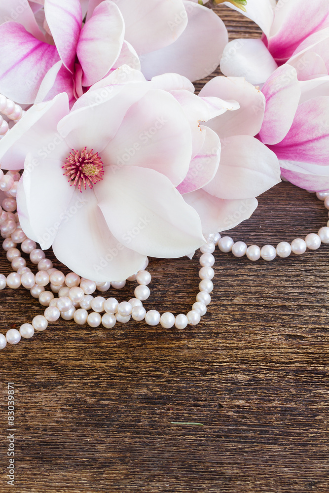 magnolia flowers with pearls on wooden table magnolia flowers with pearls on wooden table