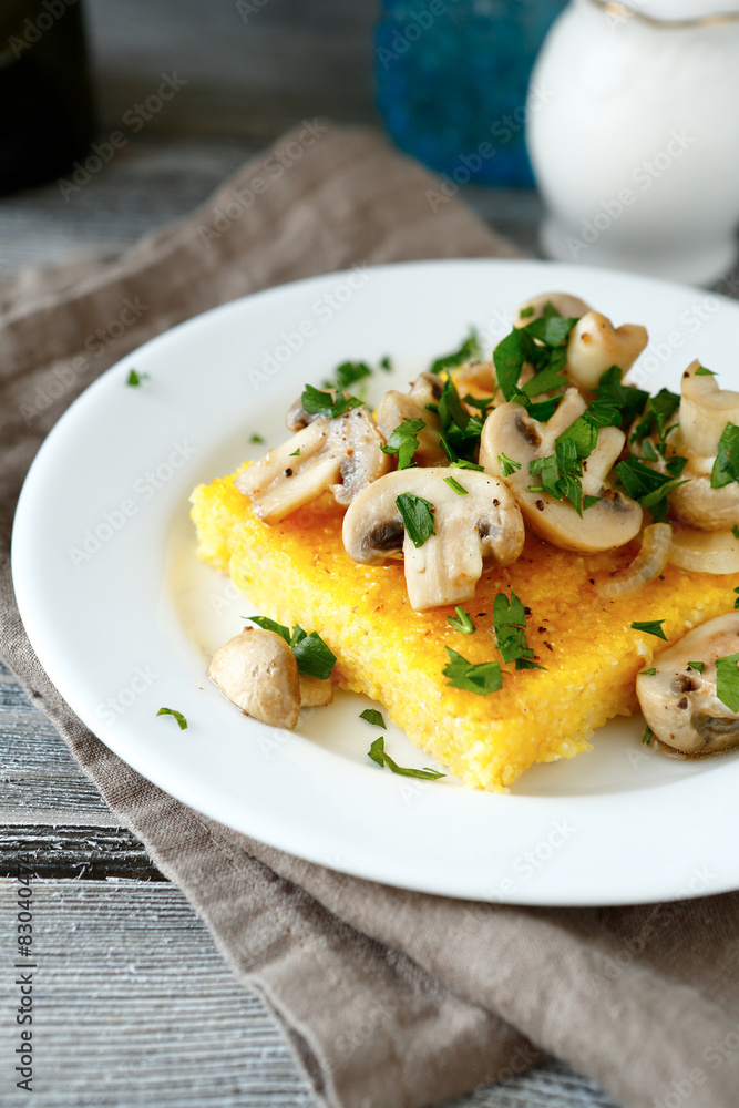 Tasty polenta with mushrooms in a white plate Tasty polenta with mushrooms in a white plate