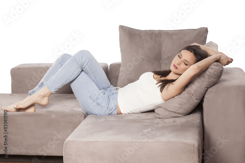 a beautiful young woman lying on the couch and sleeping
