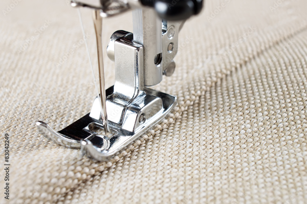 sewing machine foot and item of clothing - obrazy, fototapety, plakaty 
