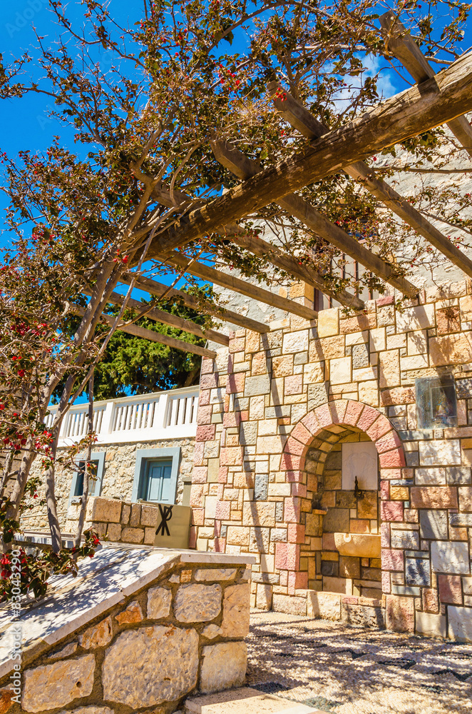Fototapeta premium Pergola in front on typial Greek balcony of stone house in Greec