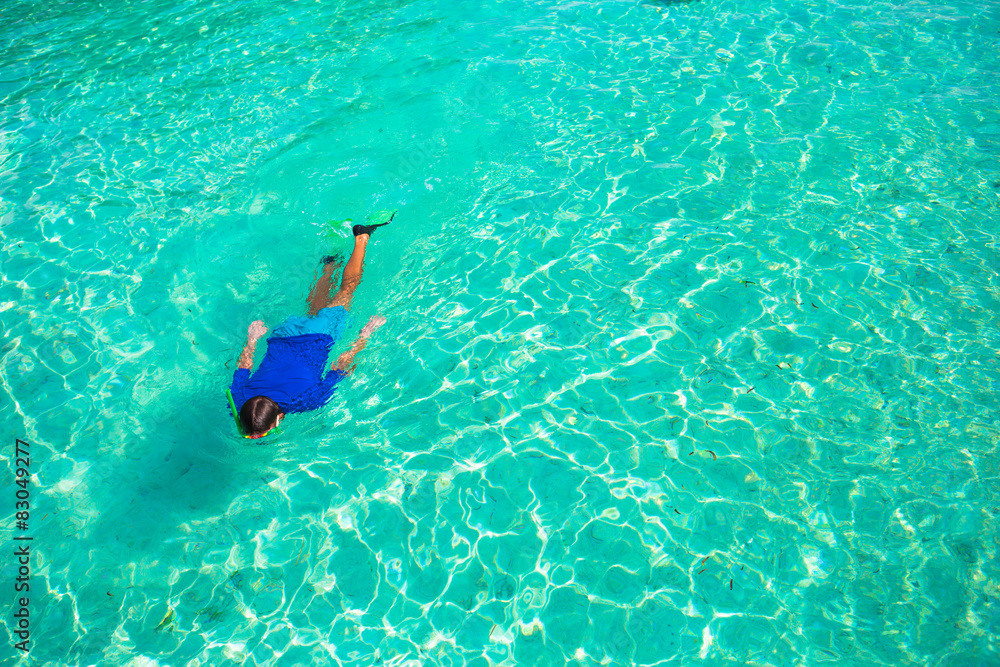 Fototapeta premium Young man snorkeling in clear tropical turquoise waters