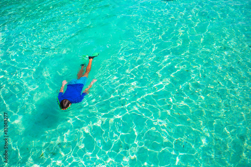 Young man snorkeling in clear tropical turquoise waters