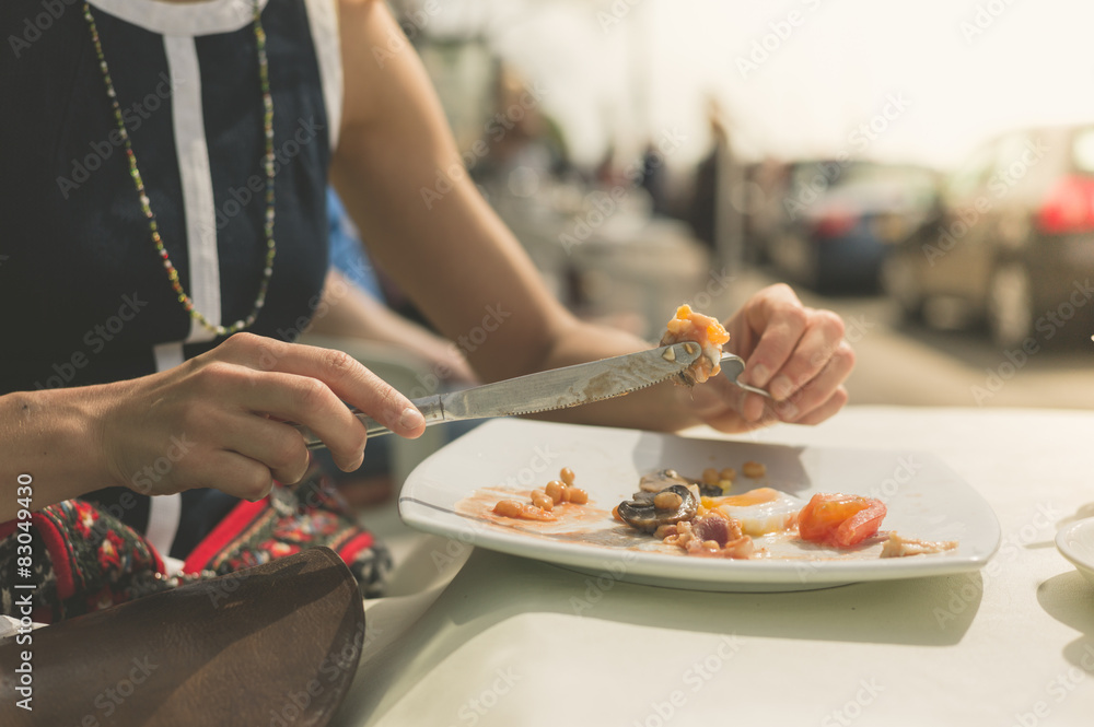 Young woman having breakfast outside