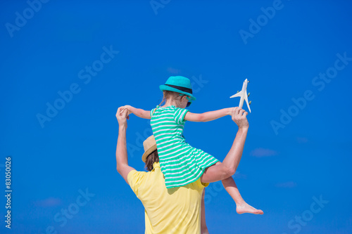 Young man and little girl with miniature of airplane at beach