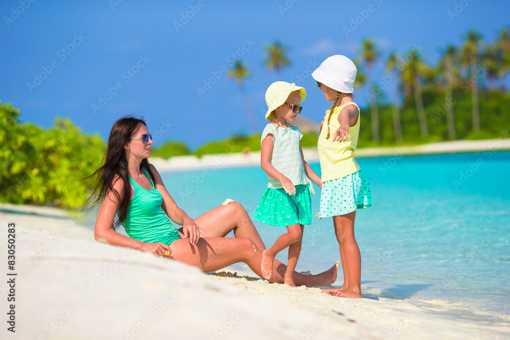 Young mother and two her little girls at exotic beach on sunny Young mother and two her little girls at exotic beach on sunny