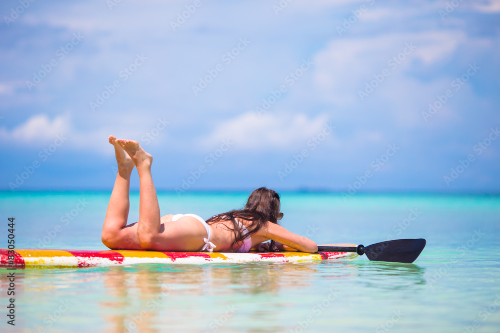 Active young woman on stand up paddle board