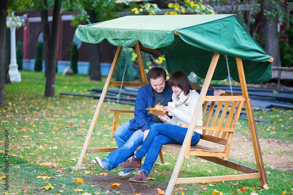 Romantic couple having fun together on the swing Romantic couple having fun together on the swing